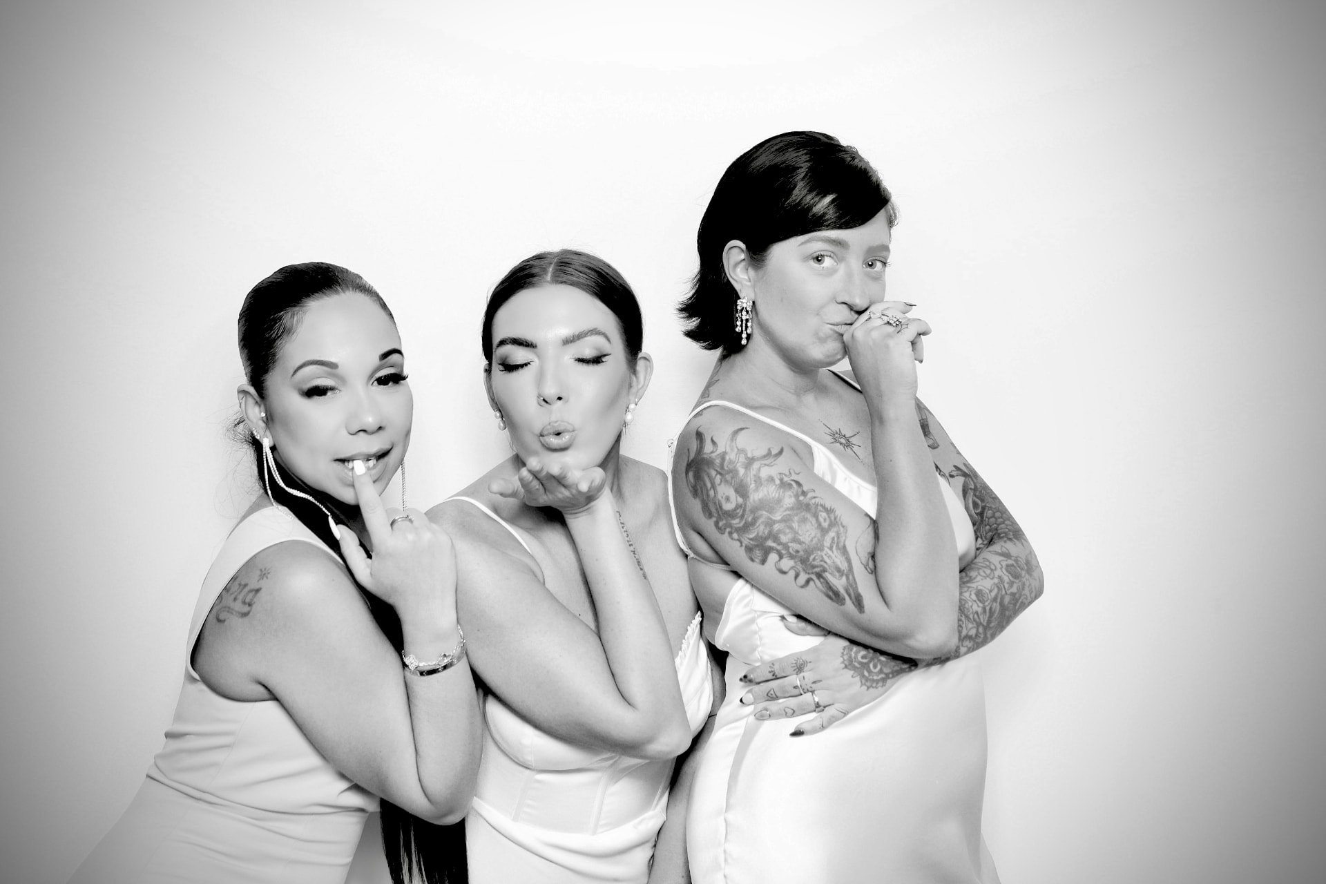 Three bridesmaids in white posing in the Glam Black & White Photo Booth