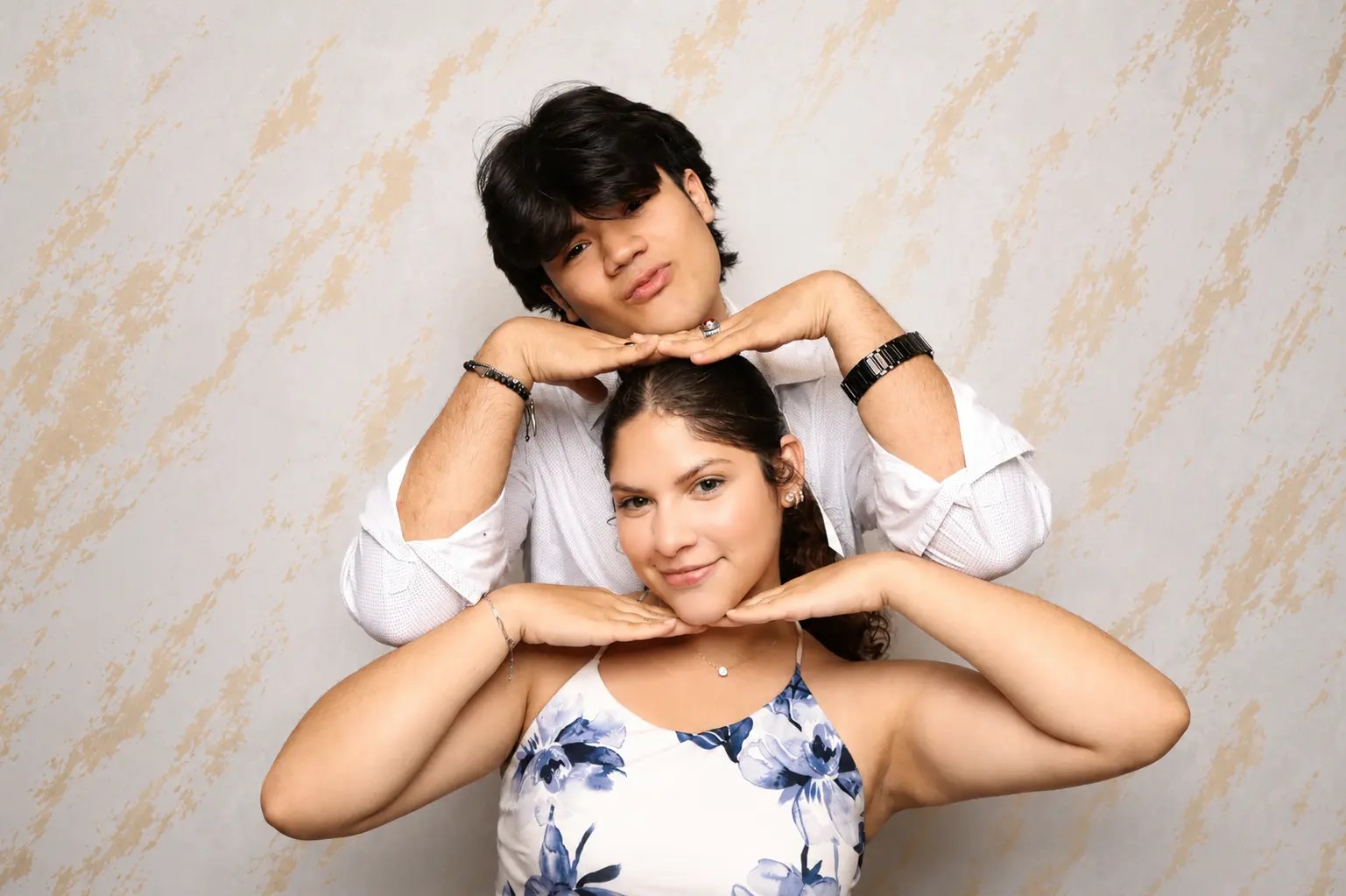 Couple recreating a framed-face pose selected on the booth screen