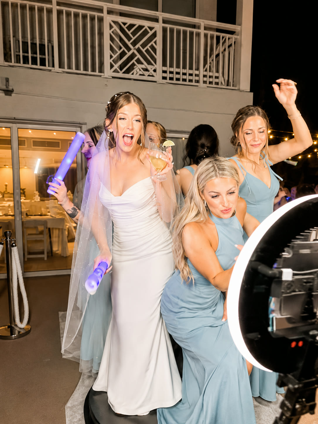 Bride and bridesmaids celebrating with glow props at the 360 booth