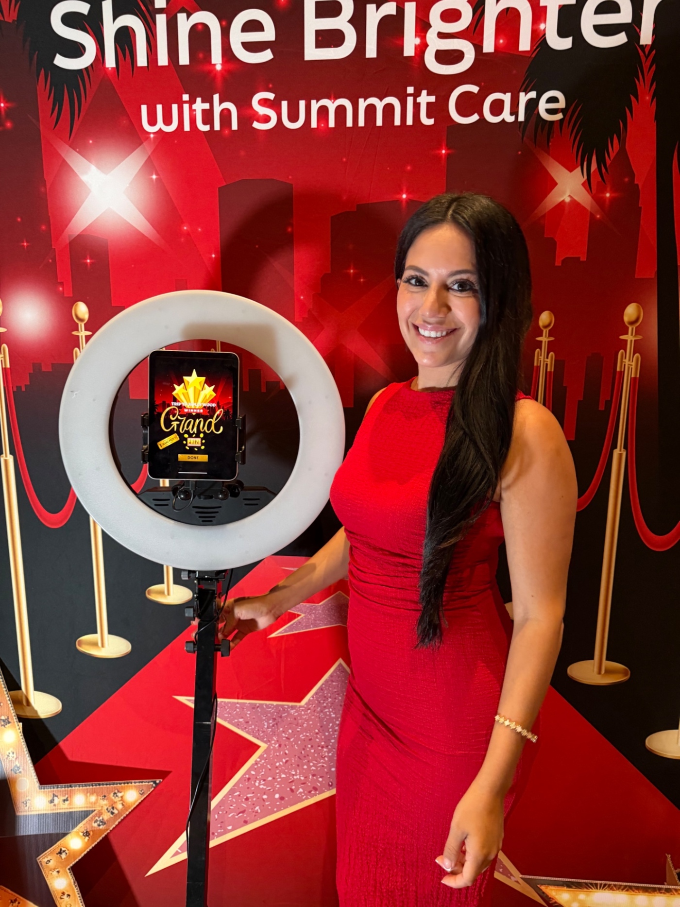 An attendee poses beside the Summit Care ring light and spin-to-win tablet