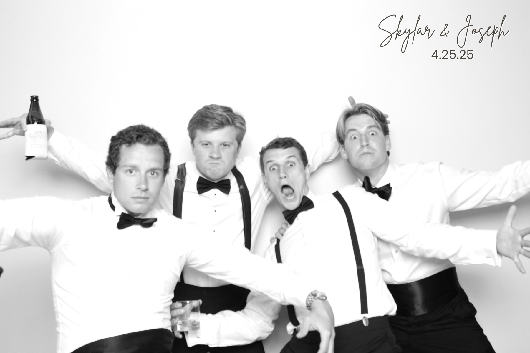 Four guests in formalwear lean into an energetic group pose against a bright backdrop.