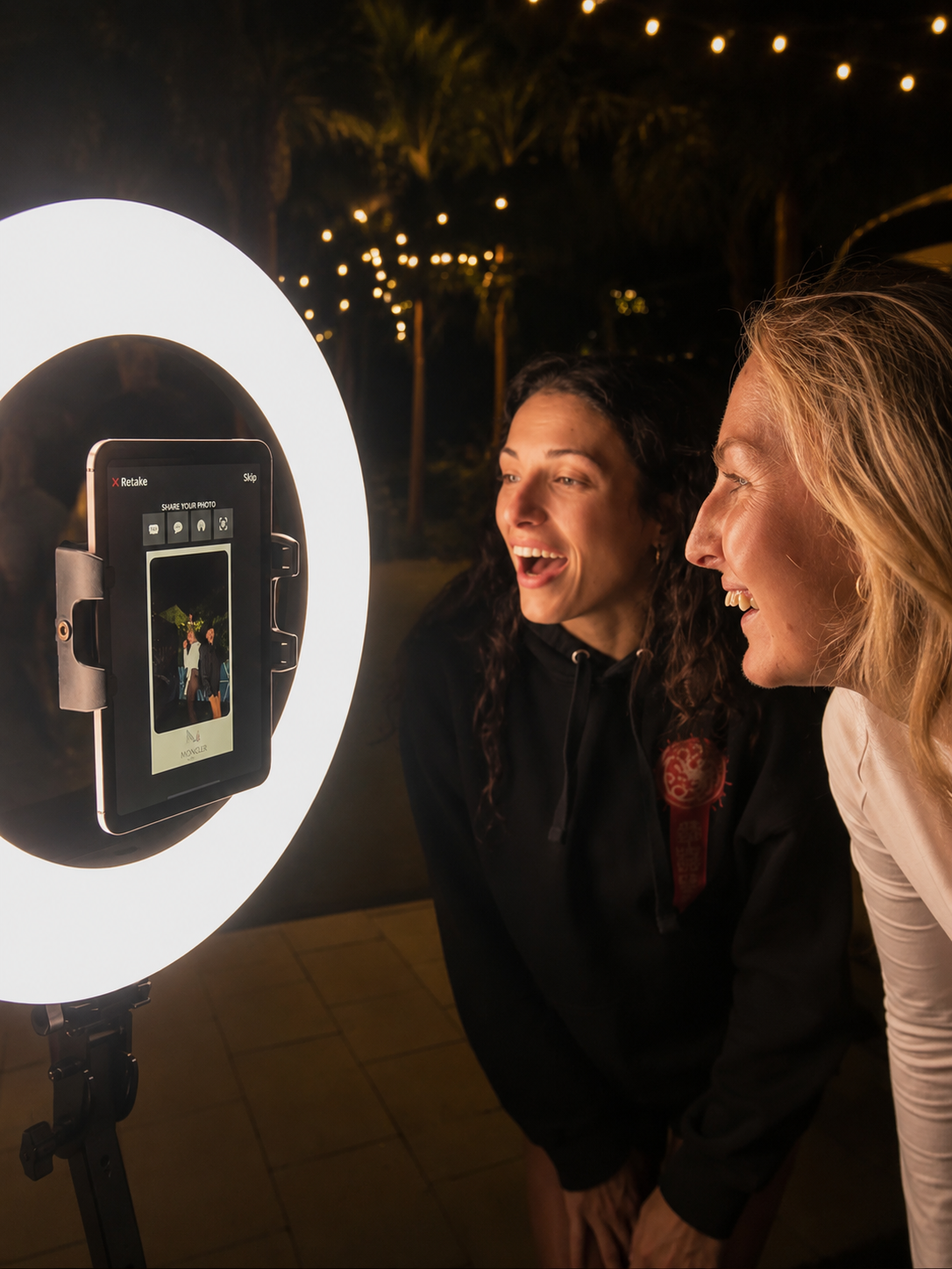 Guests sharing their photo at a SnapJoy ring light booth at an outdoor event