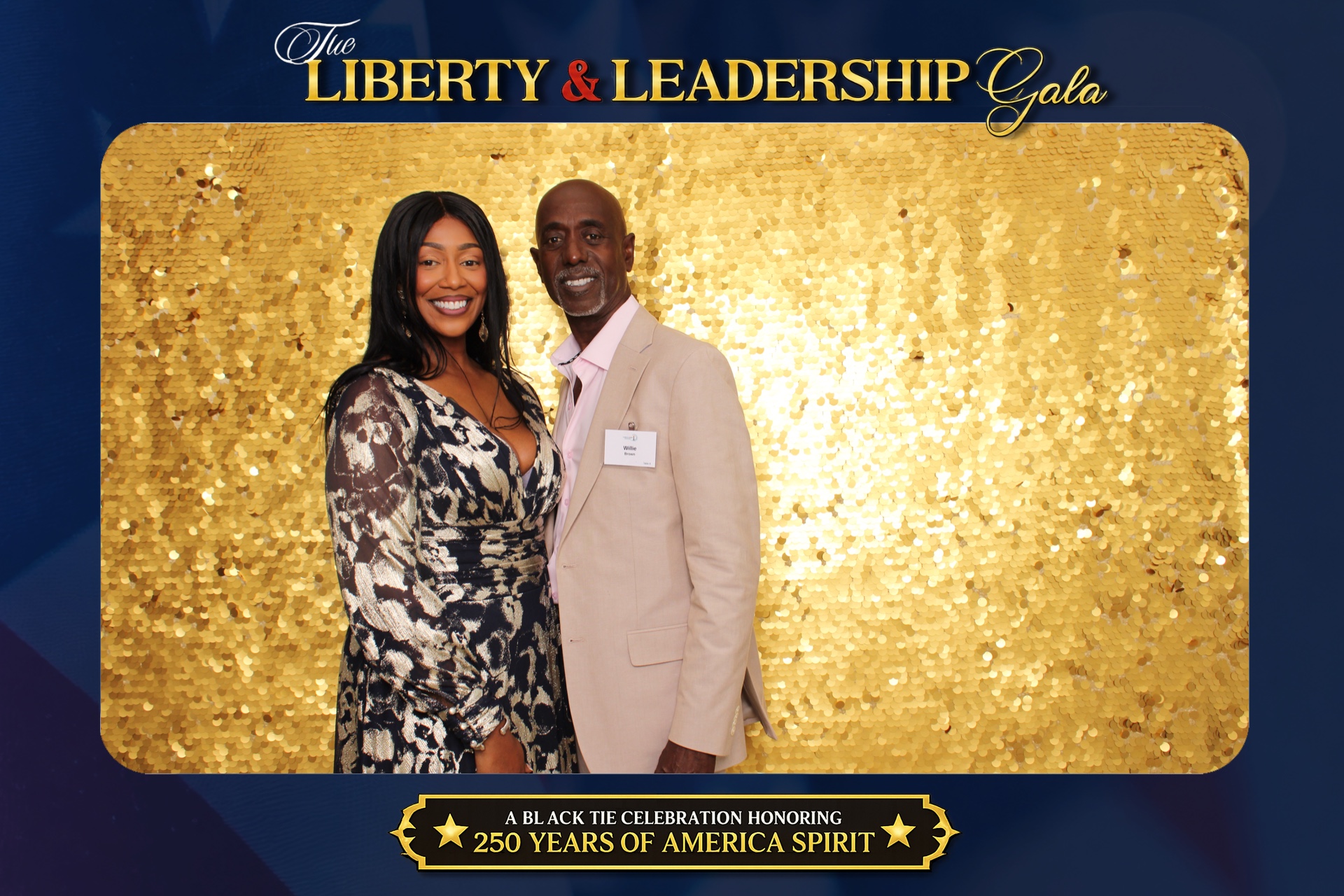 Gala guests photographed on a gold sequin backdrop with custom Liberty & Leadership Gala graphics