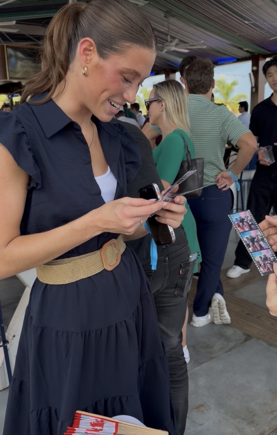 A guest receiving her printed photo strip at the event