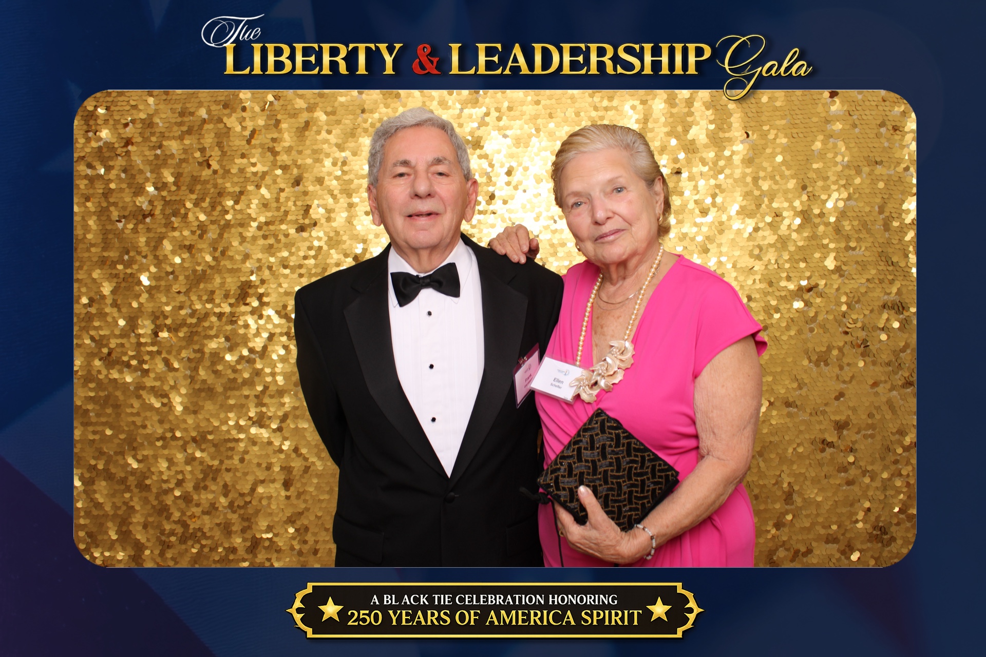 Black tie couple in a gala portrait framed by custom Liberty & Leadership Gala event graphics