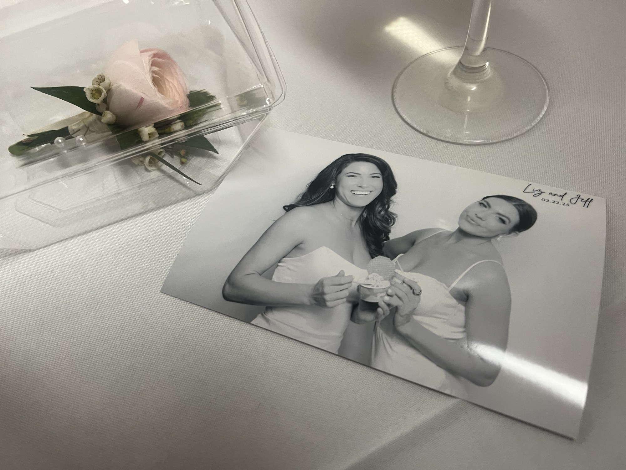 A printed black-and-white photo keepsake from Liz and Jeff's wedding resting on a reception table