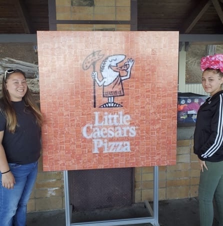 Guests beside a completed Little Caesars Pizza logo photo mosaic