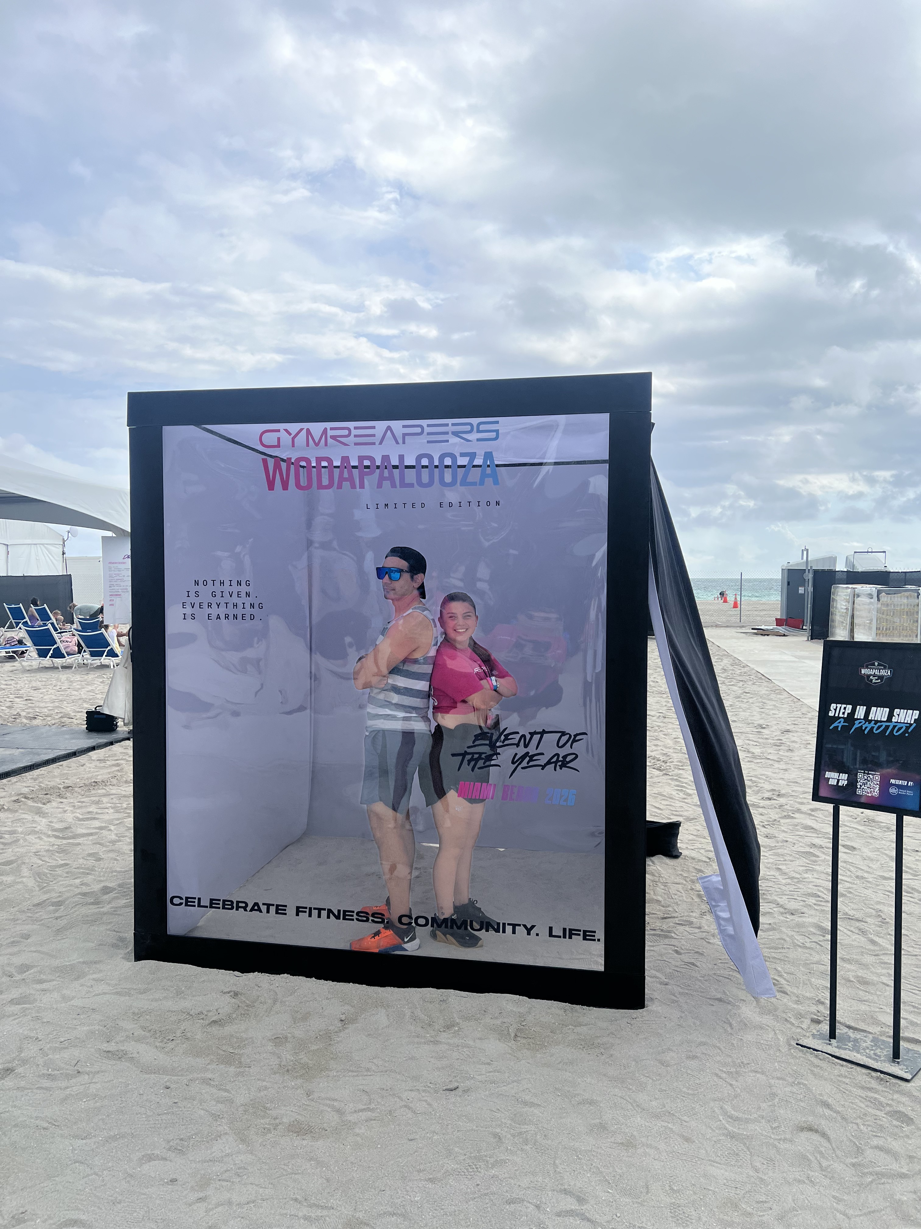 Two Wodapalooza attendees posing back to back inside the life-size Magazine Cover Studio on Miami Beach