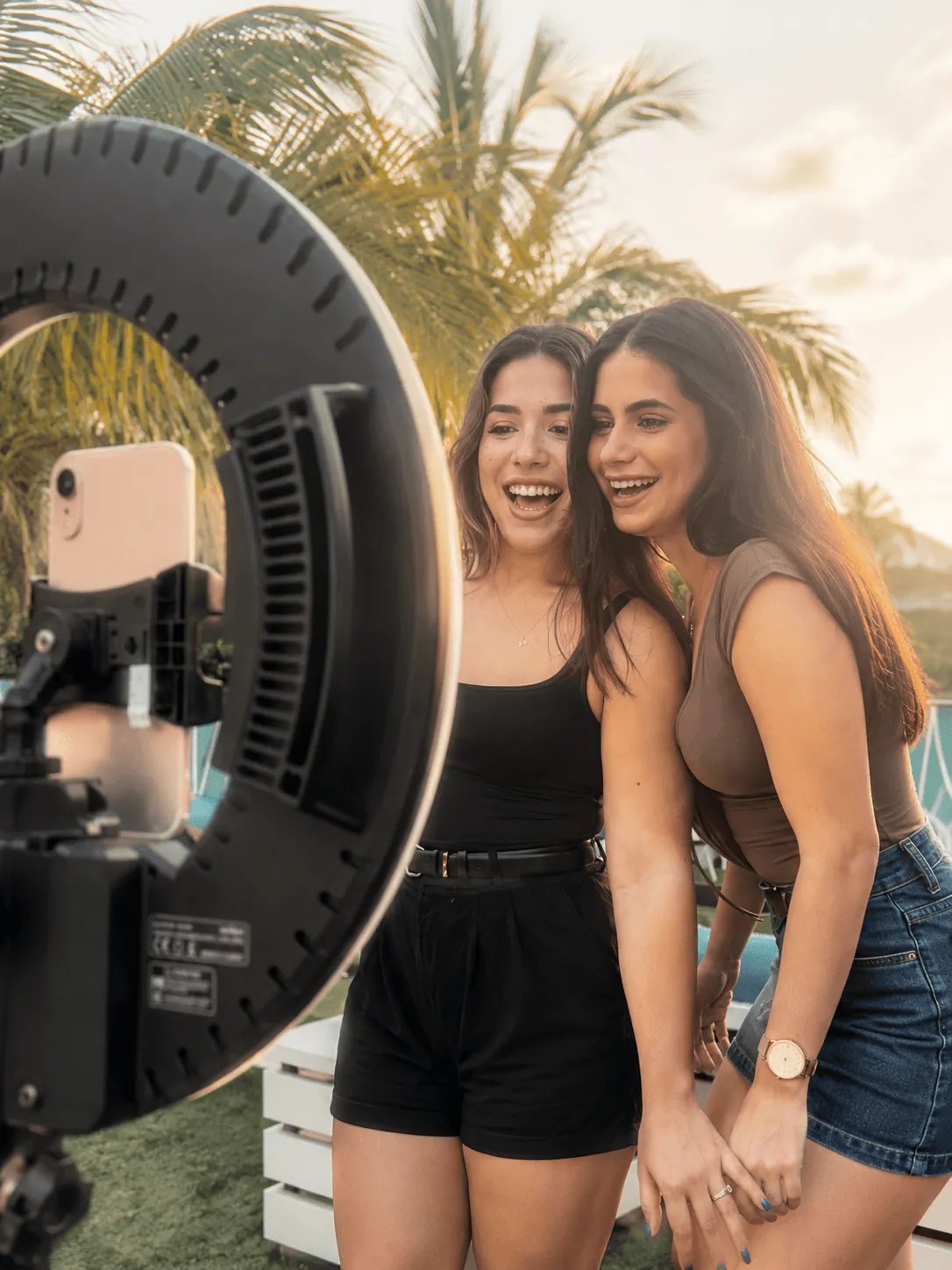 Friends laughing together under a sunset ring light booth