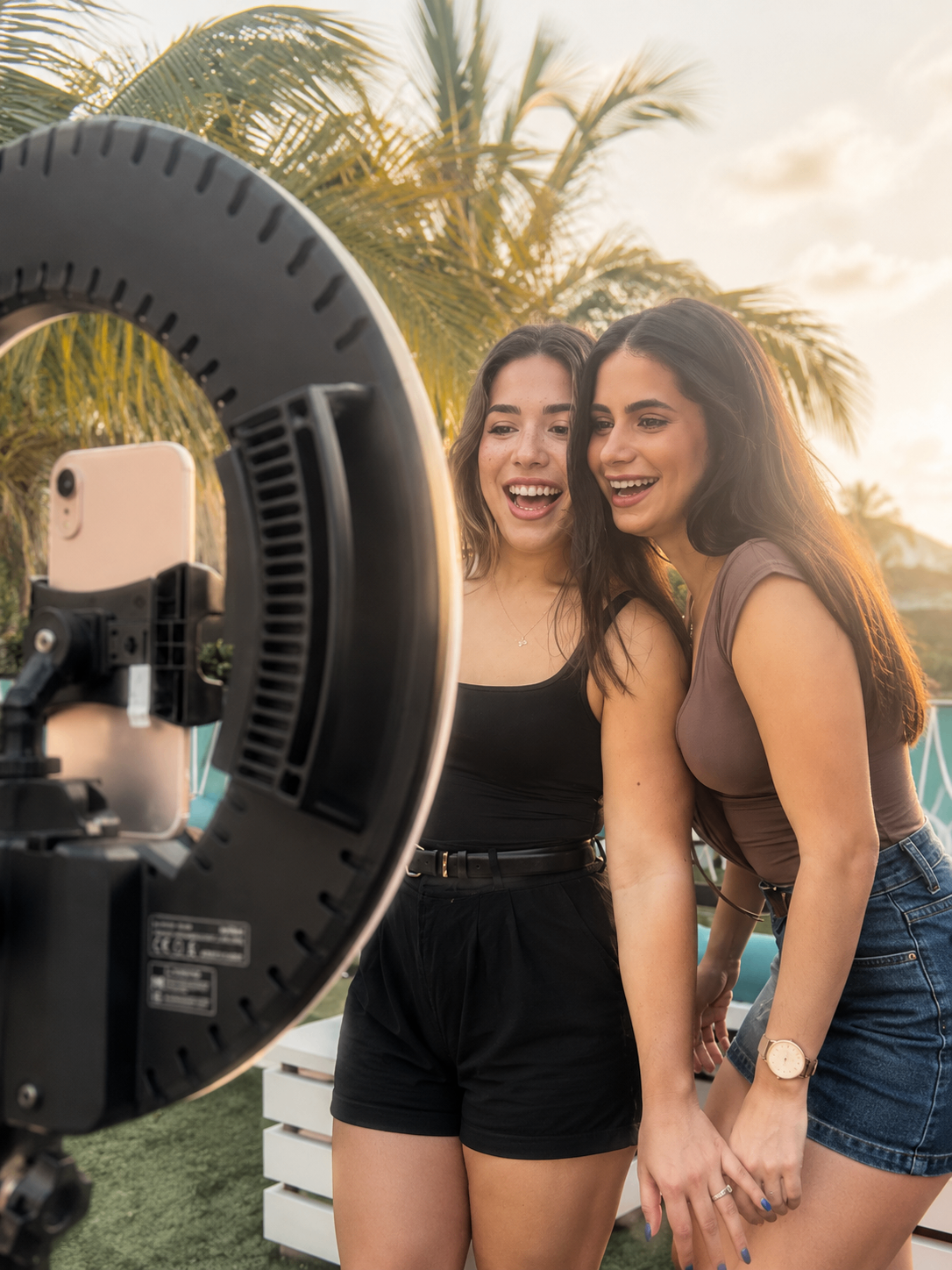 Friends laughing together under a sunset ring light booth