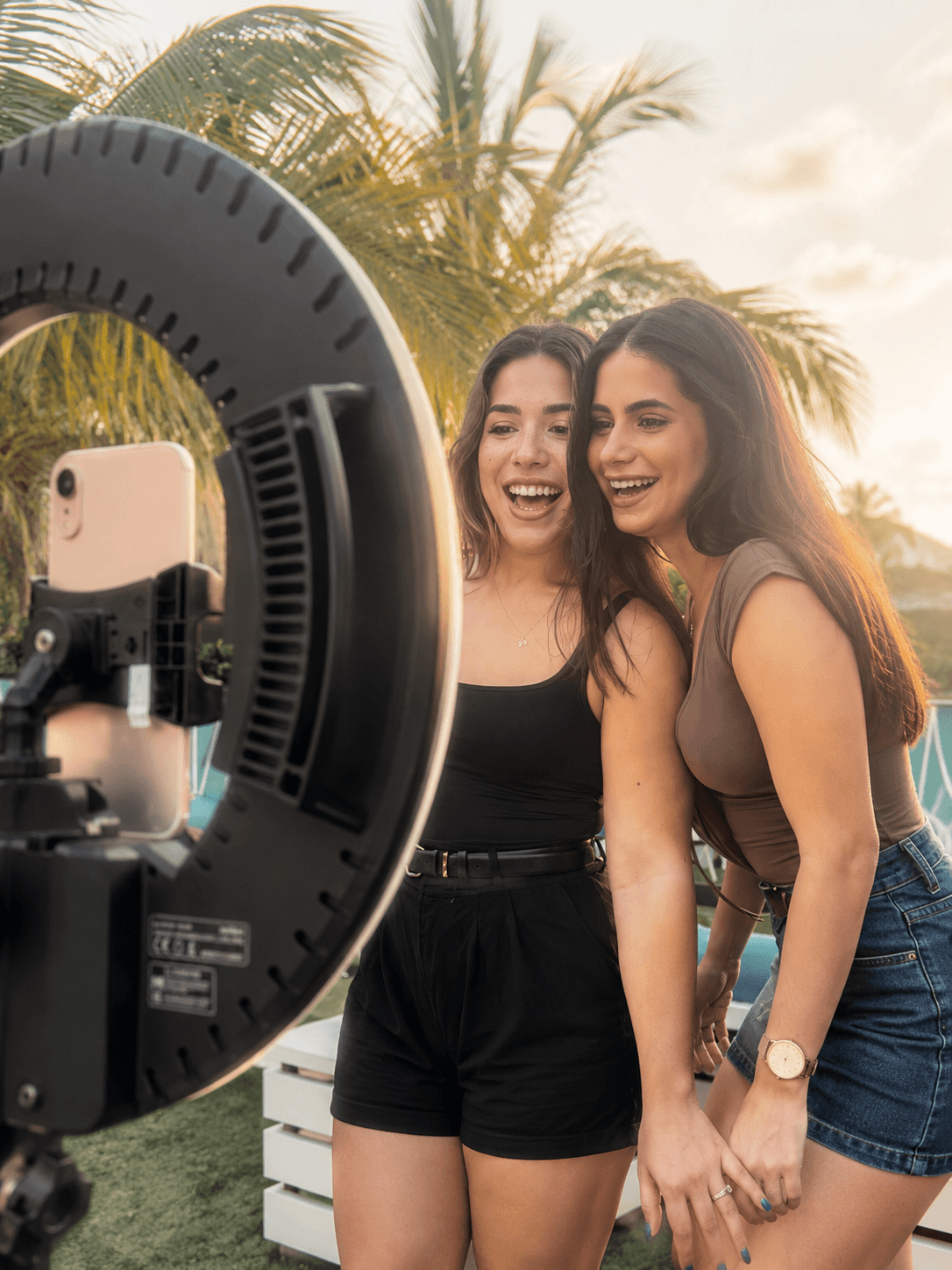 Friends laughing together under a sunset ring light booth