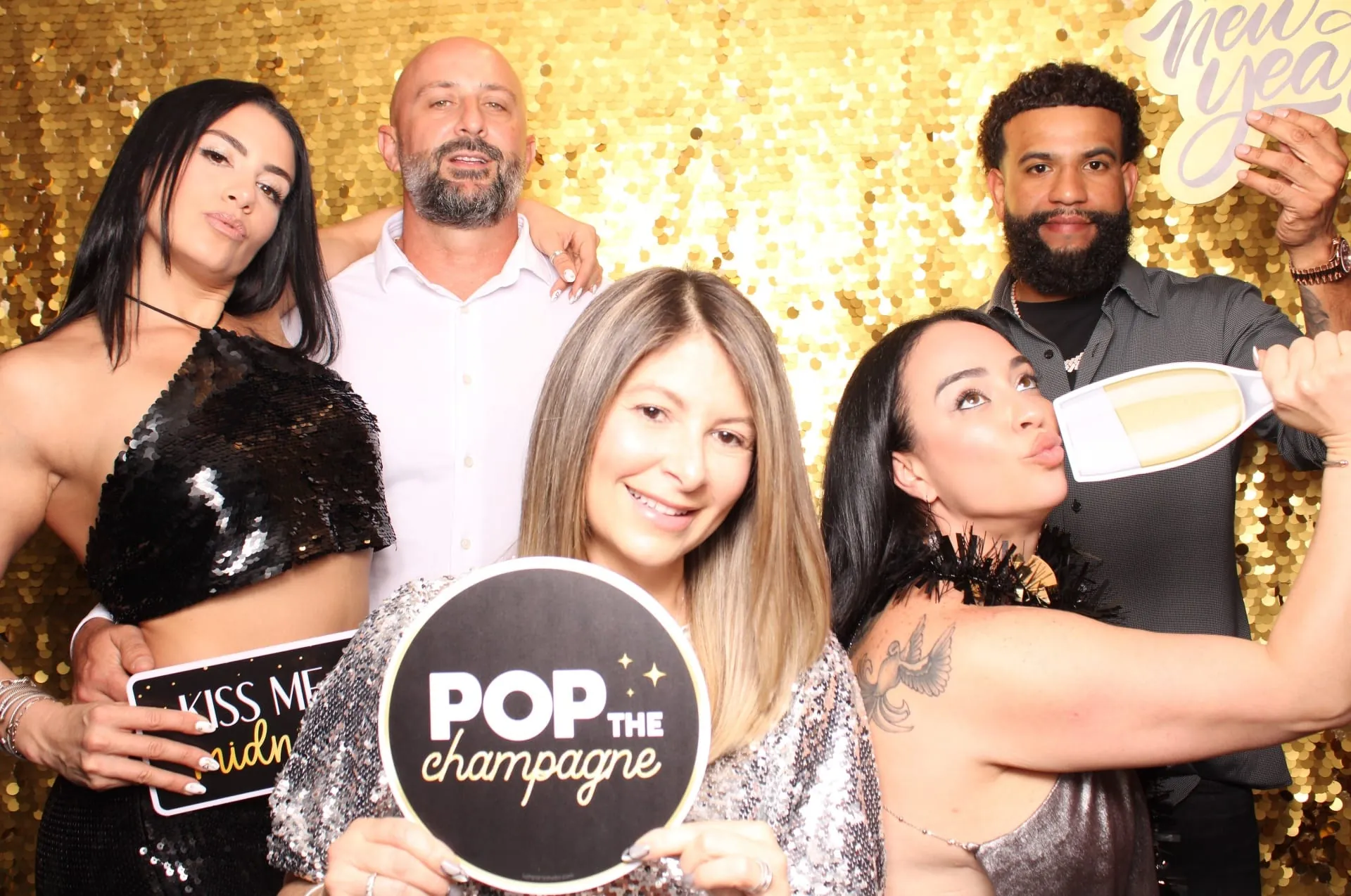 Pop the champagne group photo on gold sequin wall