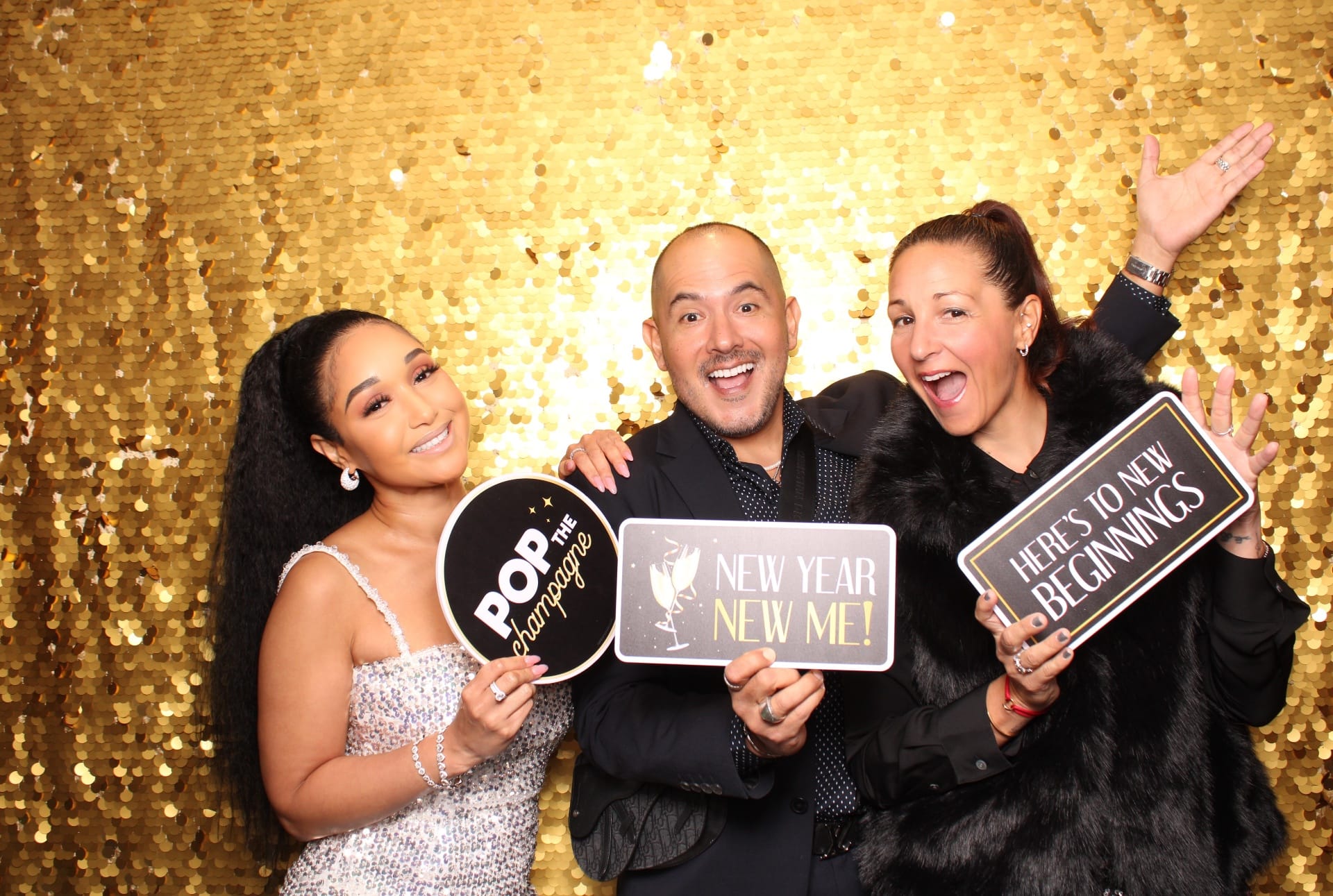 Trio with New Year New Me and Pop the Champagne signs