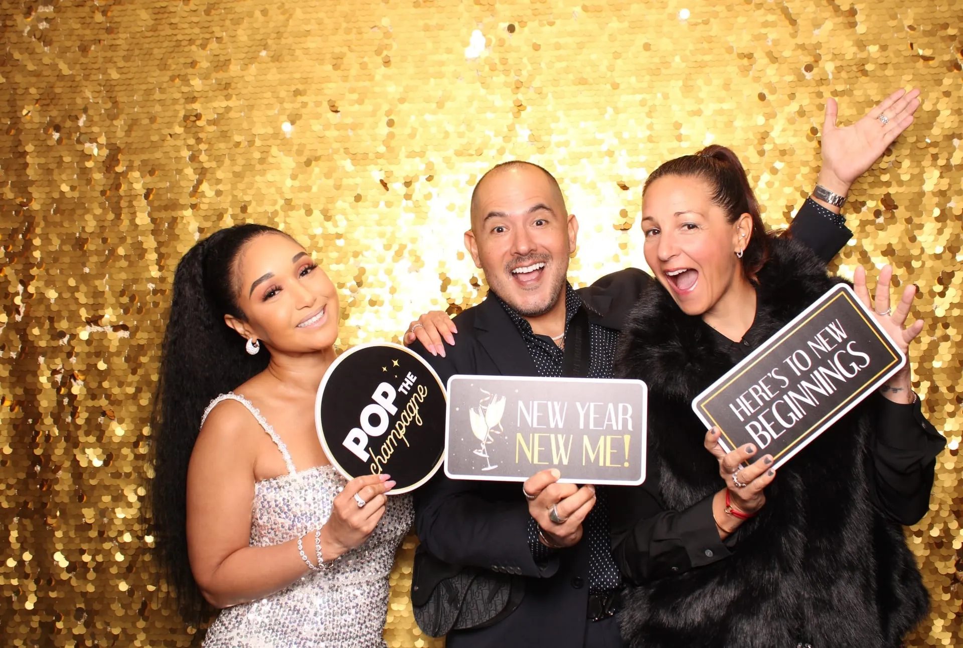 Trio with New Year New Me and Pop the Champagne signs