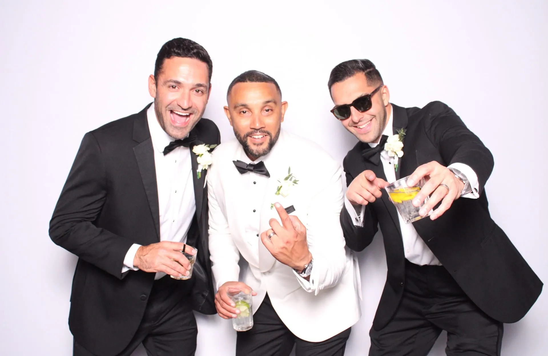 Three groomsmen toasting in tuxedos