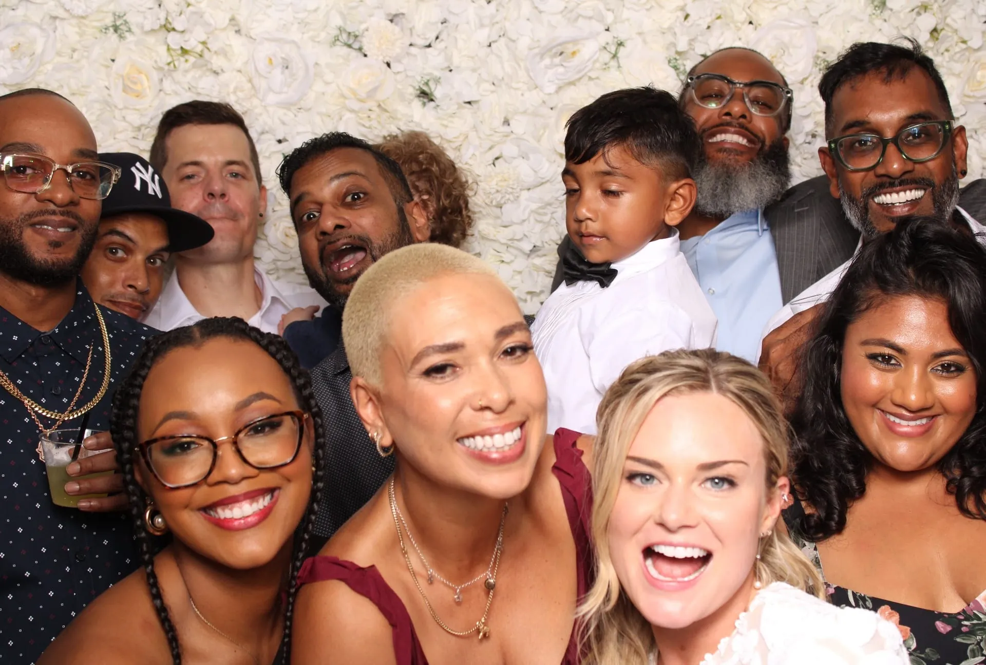 Large celebration group portrait at the floral backdrop