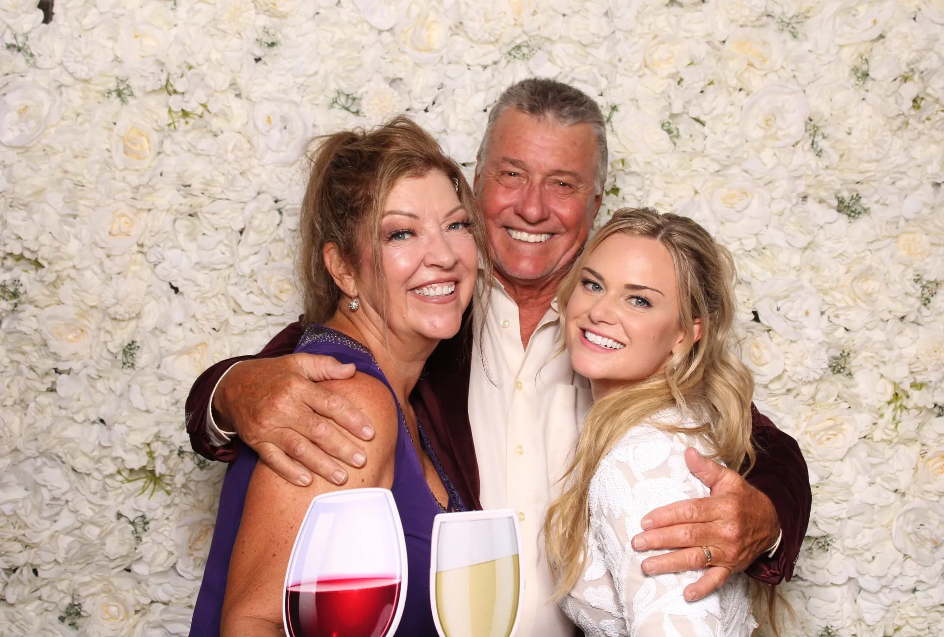 Three guests posing with champagne prop glasses