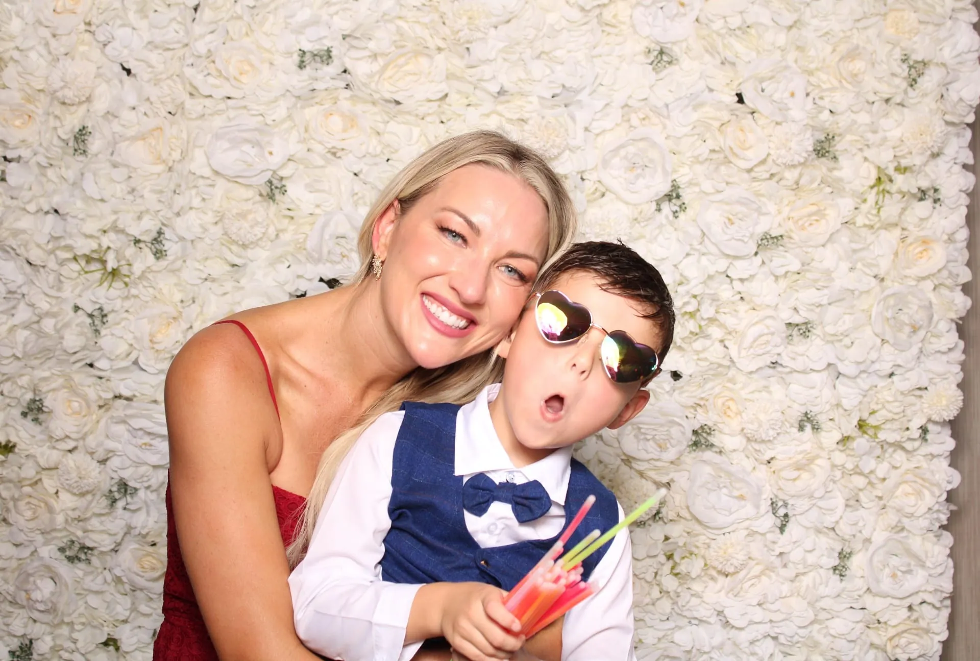 Woman and child posing in front of the white floral wall