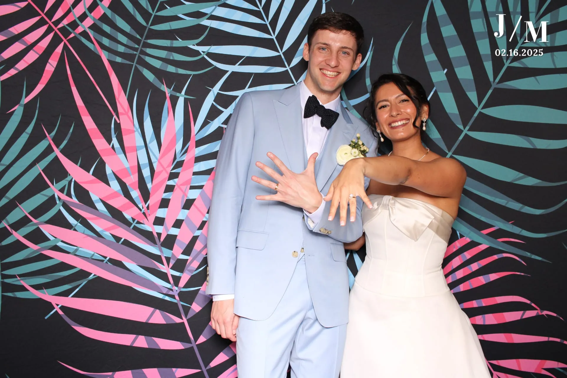 Bride and groom showing rings on tropical backdrop