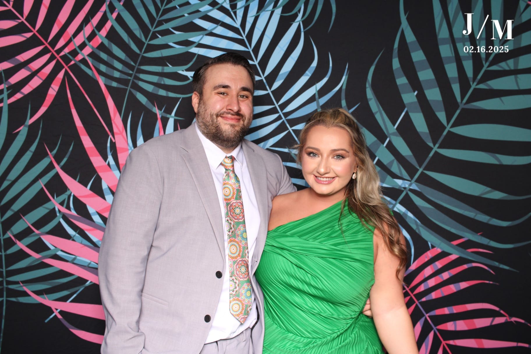 Couple smiling on tropical palm backdrop