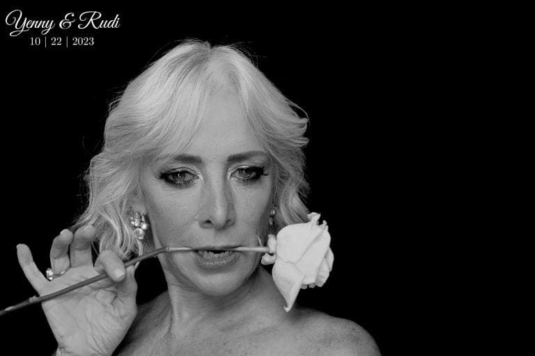 Black and white editorial portrait of bride with white rose